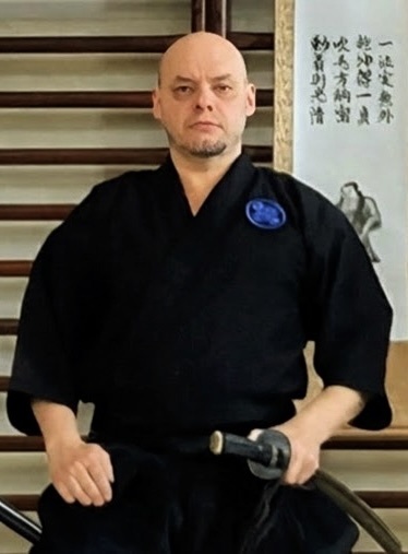 Werner Zährl seated in martial arts clothing with his sword